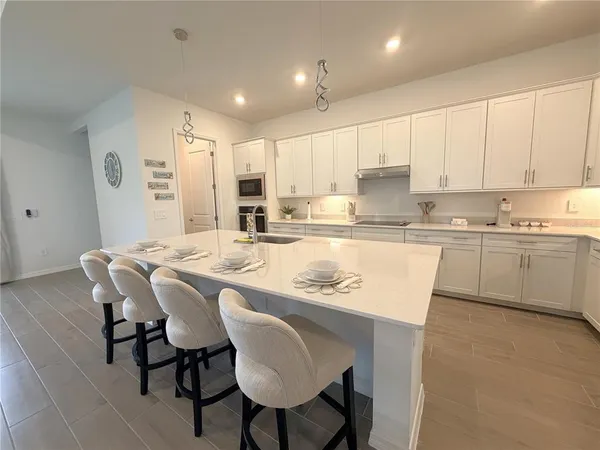 a kitchen with kitchen island granite countertop a sink counter and chairs