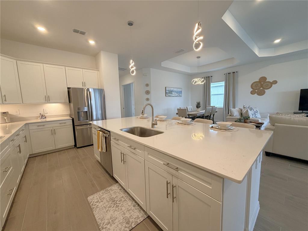 13081 Tulum Loop Venice, FL 34293 - Photo 6 of 48 a kitchen with stainless steel appliances kitchen island a sink stove and refrigerator