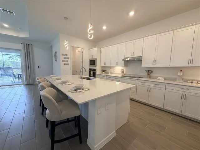 a kitchen with a sink white cabinets and stainless steel appliances