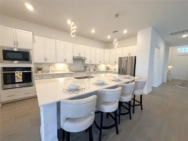 a kitchen with kitchen island a dining table and chairs