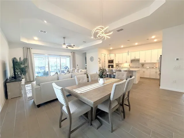 a dining room with kitchen island furniture a large window and appliances