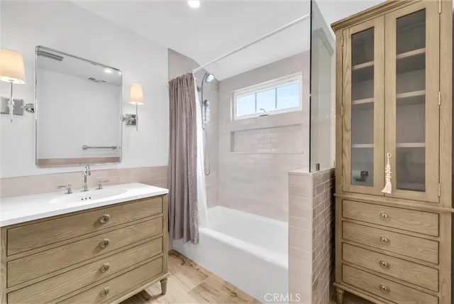 a bathroom with a granite countertop sink a mirror and a bathtub
