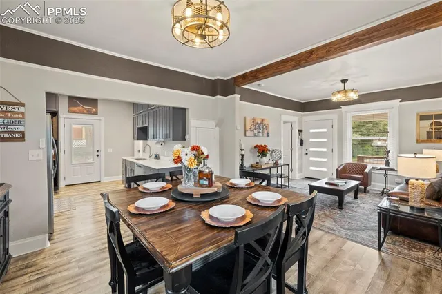 a dining room with furniture a kitchen view and wooden floor