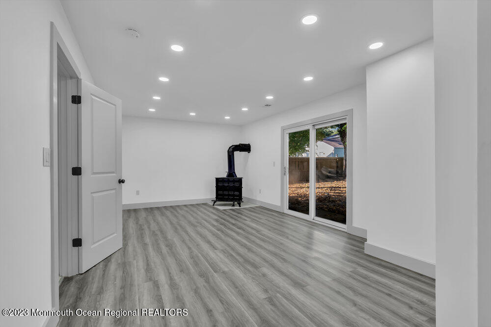 111 Sun Valley Road Toms River, NJ 08755 - Photo 12 of 51 a view of an empty room with wooden floor and a window