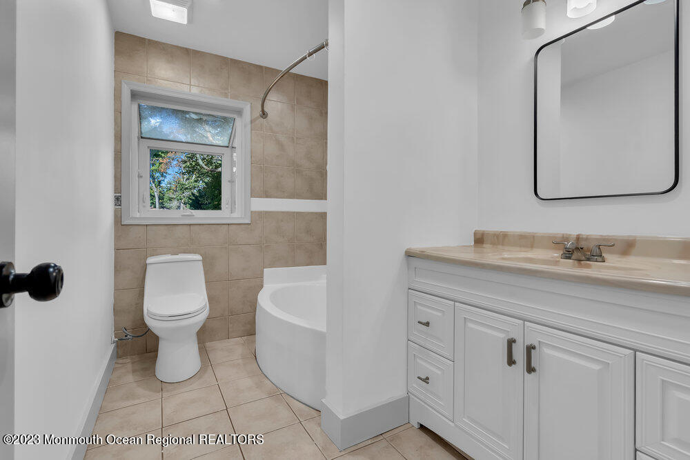 111 Sun Valley Road Toms River, NJ 08755 - Photo 34 of 51 a bathroom with a toilet a sink and mirror