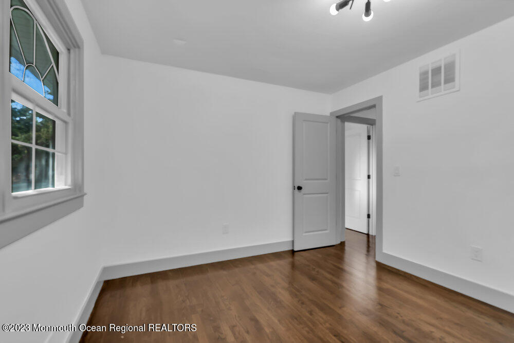 111 Sun Valley Road Toms River, NJ 08755 - Photo 36 of 51 a view of an empty room with wooden floor and a window