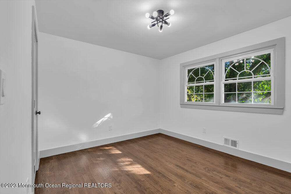 111 Sun Valley Road Toms River, NJ 08755 - Photo 39 of 51 a view of an empty room with a window and wooden floor