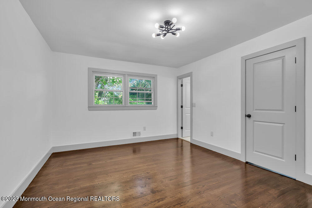 111 Sun Valley Road Toms River, NJ 08755 - Photo 45 of 51 an empty room with wooden floor and windows