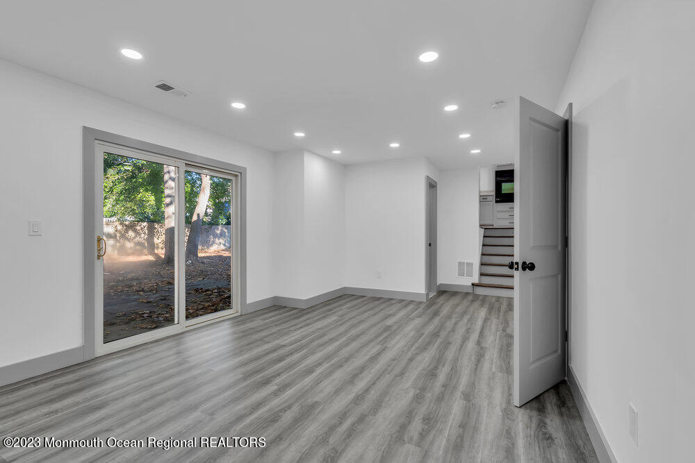 111 Sun Valley Road Toms River, NJ 08755 - Photo 9 of 51 an empty room with wooden floor and windows