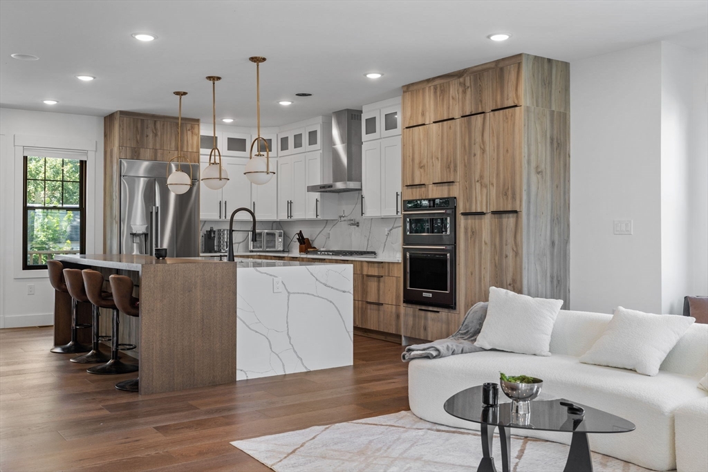 a kitchen with stainless steel appliances granite countertop a refrigerator and a stove top oven