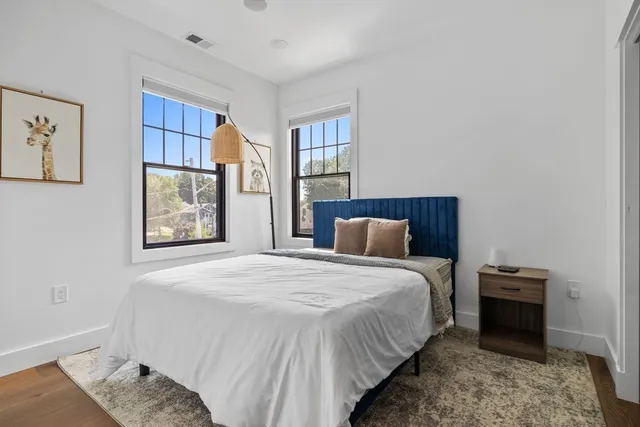 a bedroom with bed and wooden floor