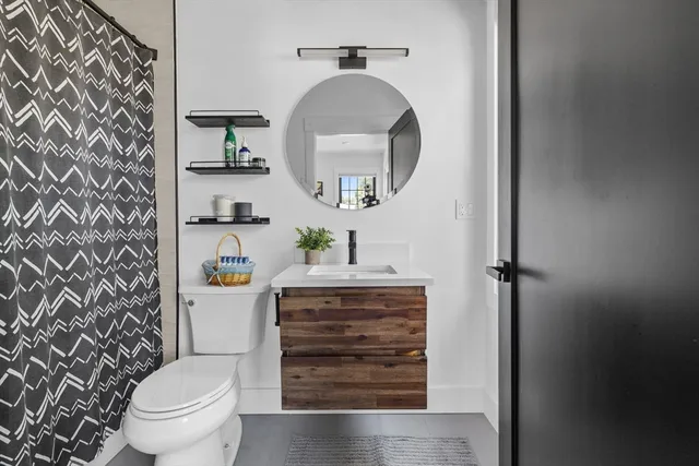 a bathroom with a granite countertop toilet and a sink