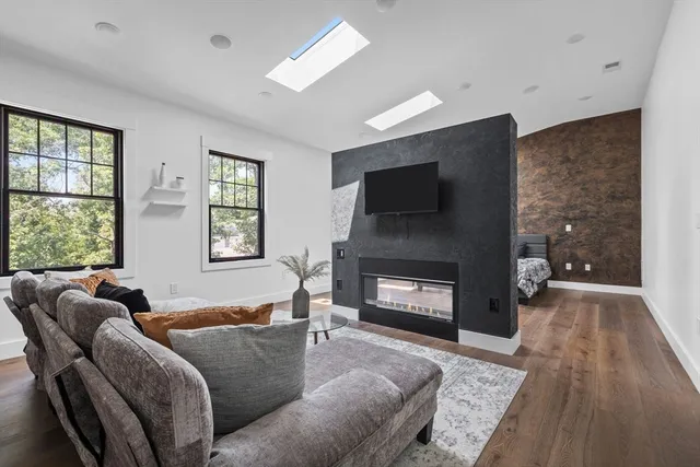 a living room with furniture a flat screen tv and a fireplace