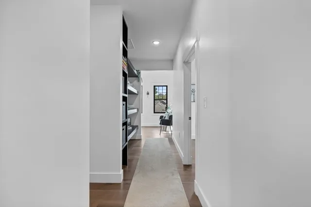 a view of a hallway with wooden floor and staircase
