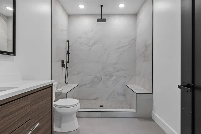 a bathroom with a shower a toilet and sink