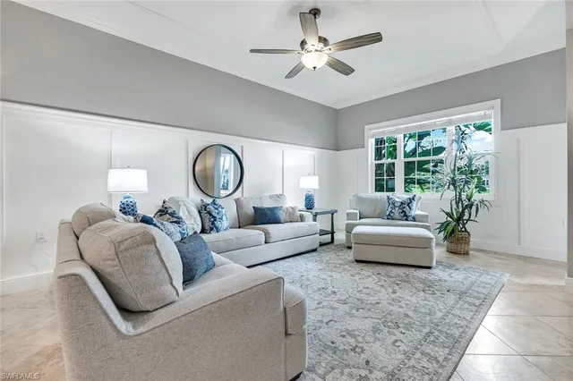 a living room with furniture a rug potted plant and a large window