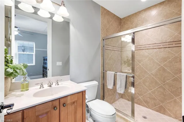 a bathroom with a sink vanity granite toilet and shower