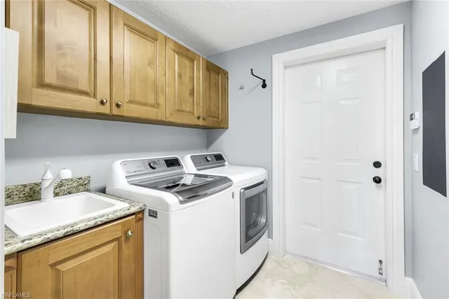 a utility room with sink dryer and washer
