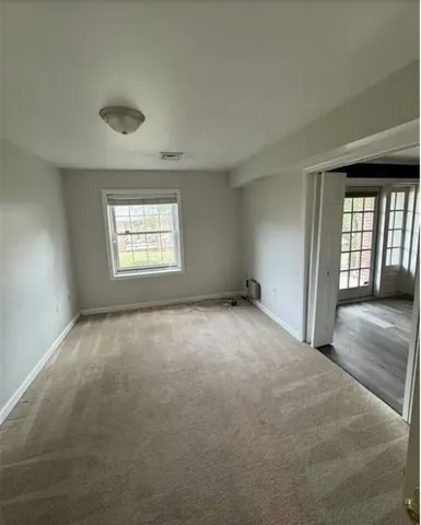 an empty room with a fireplace and windows
