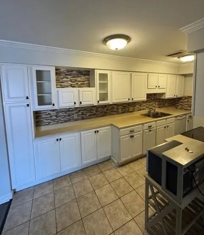 a kitchen with a sink cabinets and window