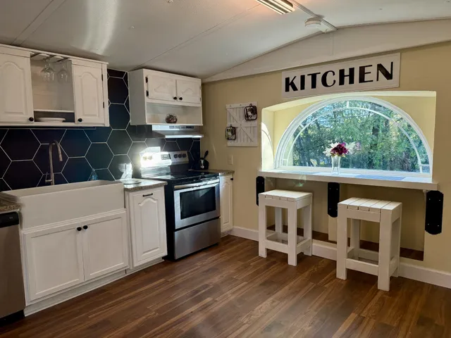 a kitchen with stainless steel appliances white cabinets and wooden floor