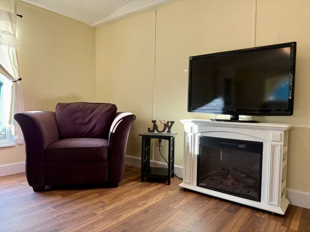 a living room with furniture a fireplace and a flat screen tv