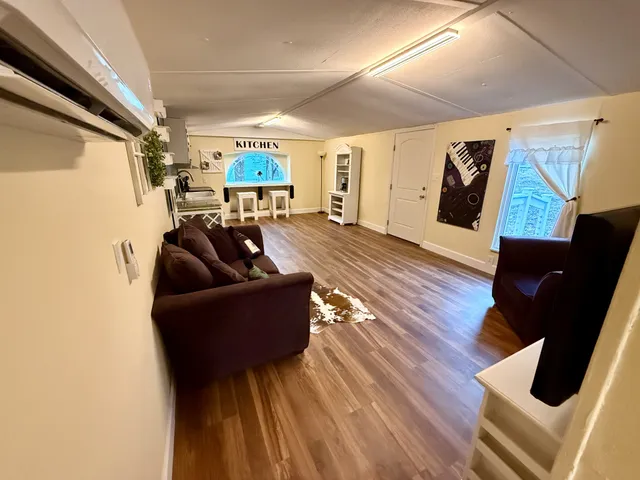 a living room with furniture and wooden floor