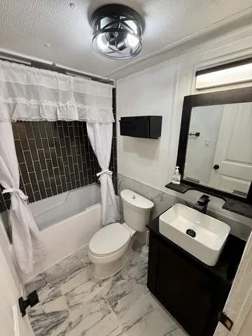 a bathroom with a sink toilet a mirror and bathtub