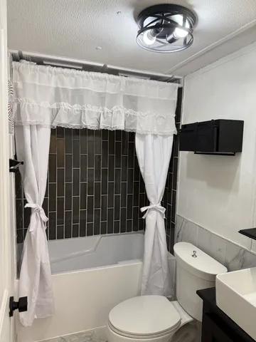 a bathroom with a toilet a sink and bathtub