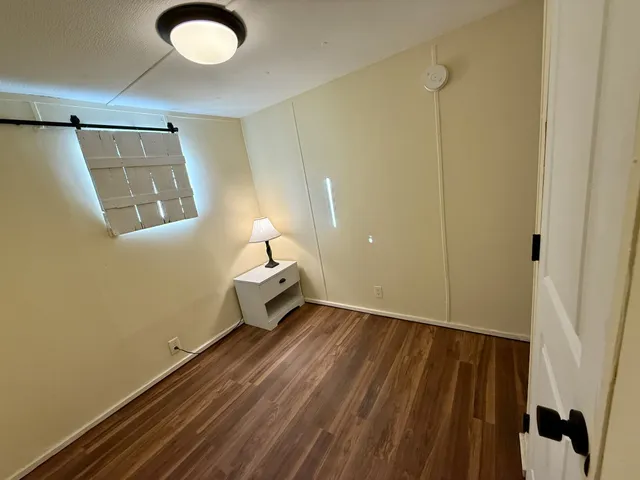 a view of a room with wooden floor and bathroom