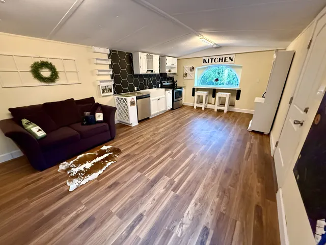 a living room with furniture and a wooden floor