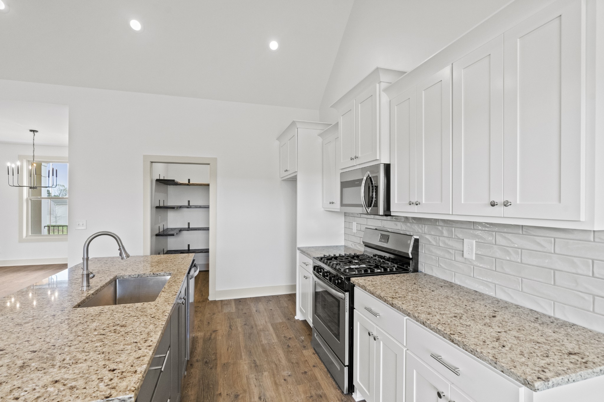 3390 Calista Road White House, TN 37188 - Photo 10 of 25 a kitchen with granite countertop a sink a stove and cabinets