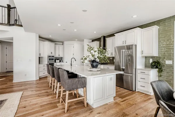 a kitchen with stainless steel appliances kitchen island granite countertop a refrigerator and a dining table