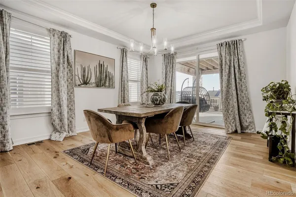 a dining room with furniture a chandelier and wooden floor