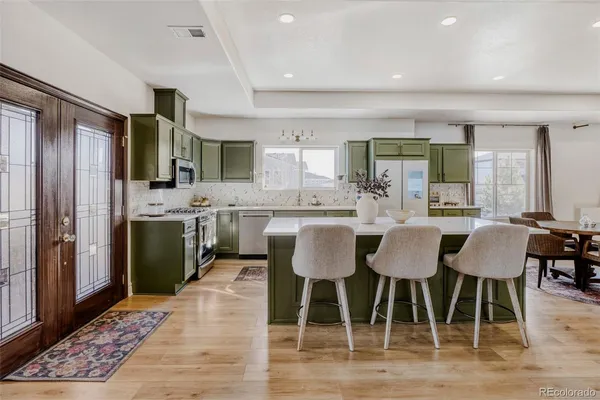 a kitchen with a dining table chairs and white appliances