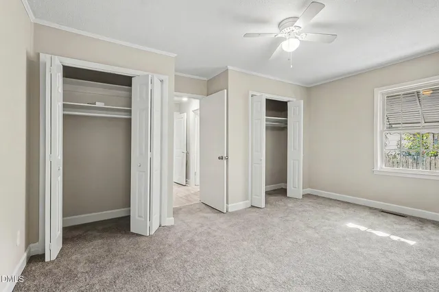 a view of empty room with window and ceiling fan