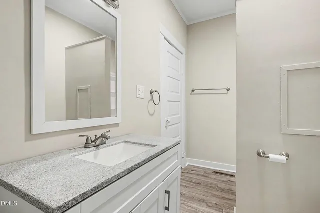 a bathroom with a granite countertop sink and a mirror