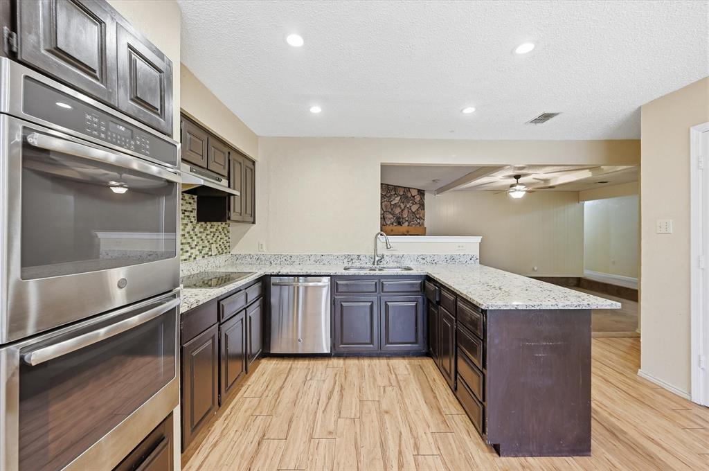1503 North Fielder Road Arlington, TX 76012 - Photo 11 of 40 a kitchen with granite countertop stainless steel appliances and wooden cabinets