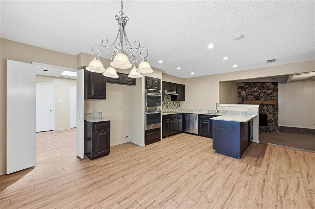 1503 North Fielder Road Arlington, TX 76012 - Photo 15 of 40 a large kitchen with stainless steel appliances granite countertop a refrigerator a oven and a wooden floors