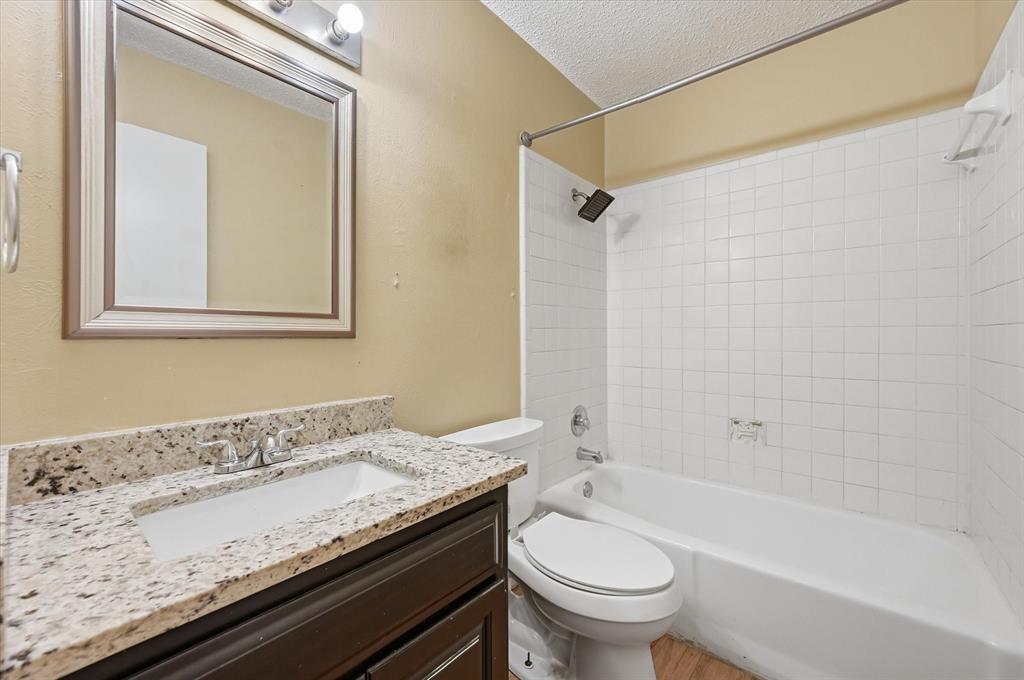 1503 North Fielder Road Arlington, TX 76012 - Photo 28 of 40 a bathroom with a granite countertop sink a toilet and shower