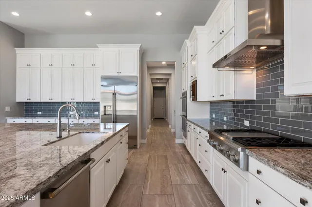 a kitchen with stainless steel appliances granite countertop a sink stove and refrigerator