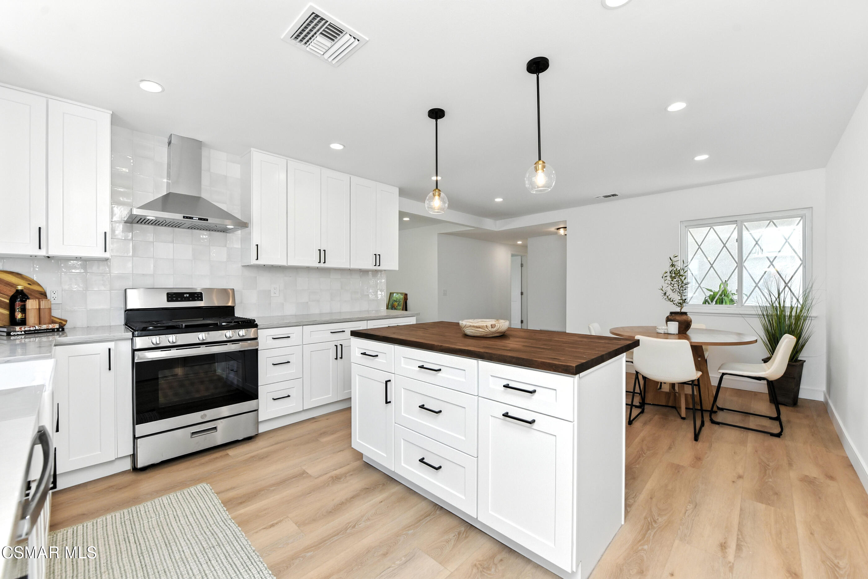 6669 Charing Street Simi Valley, CA 93063 - Photo 11 of 52 a kitchen with stainless steel appliances kitchen island granite countertop a stove a sink and a wooden cabinets