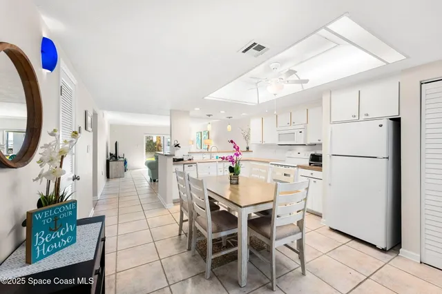 a kitchen with stainless steel appliances kitchen island granite countertop a refrigerator a stove a microwave oven with a dining table and chairs