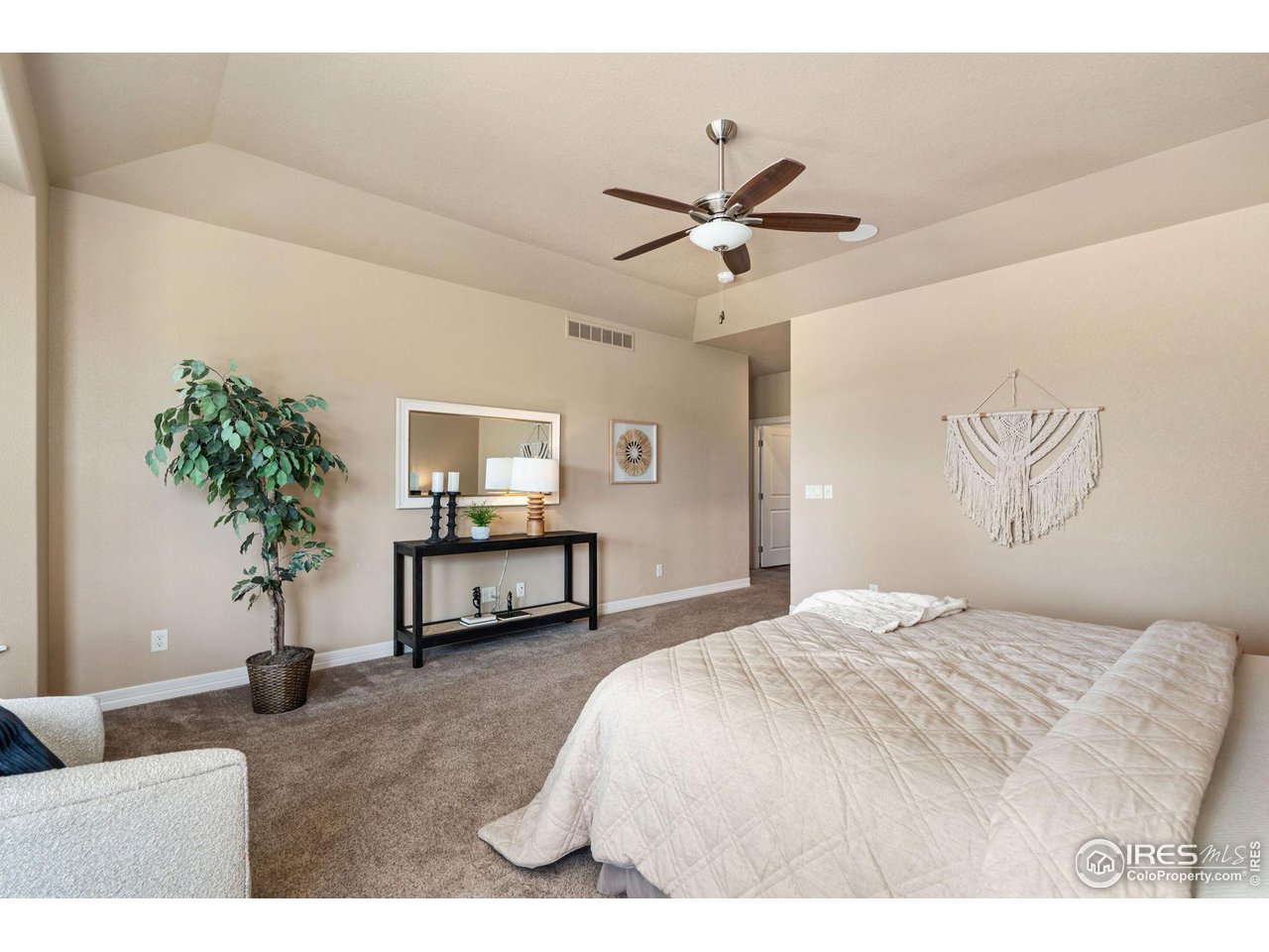 6740 Olympia Fields Court Windsor, CO 80550 - Photo 12 of 28 a bedroom with a bed and a potted plant
