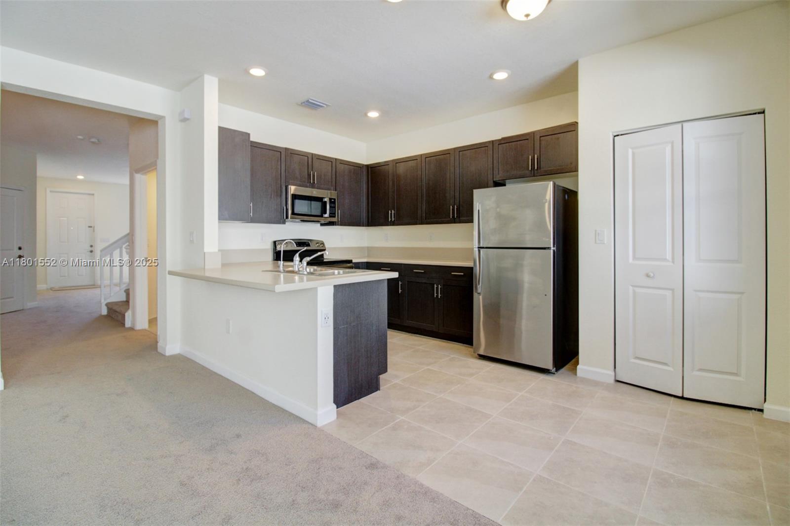 11094 West 33rd Way Hialeah, FL 33018 - Photo 12 of 46 a kitchen with a sink a refrigerator and cabinets