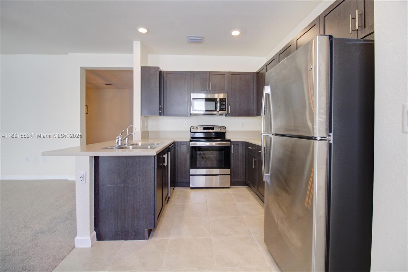 11094 West 33rd Way Hialeah, FL 33018 - Photo 13 of 46 a kitchen with stainless steel appliances granite countertop a refrigerator and a stove