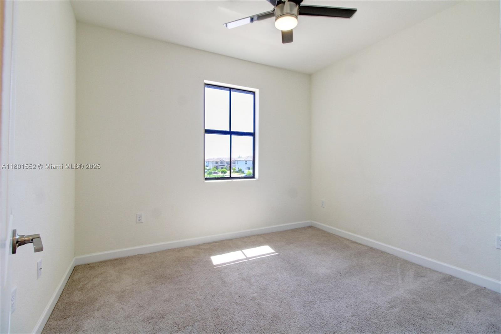 11094 West 33rd Way Hialeah, FL 33018 - Photo 26 of 46 an empty room with a chandelier fan and windows