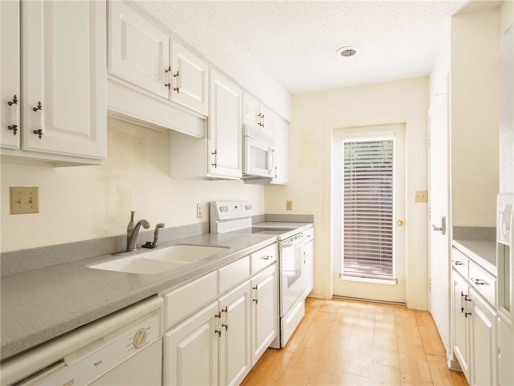 3309 Sea Marsh Road, Unit 3309 Fernandina Beach, FL 32034 - Photo 17 of 34 a kitchen with granite countertop white cabinets and white appliances