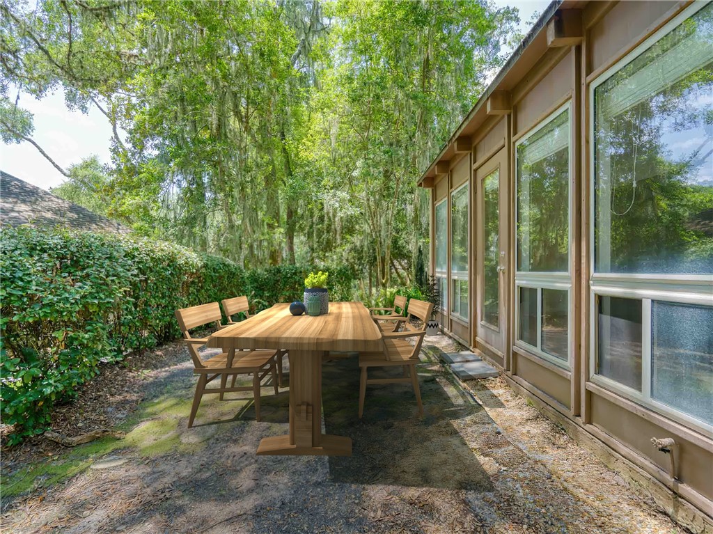 3309 Sea Marsh Road, Unit 3309 Fernandina Beach, FL 32034 - Photo 19 of 34 a view of a patio with table and chairs and floor to ceiling window
