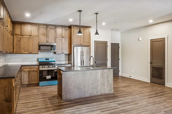 a kitchen with stainless steel appliances granite countertop a refrigerator and a stove top oven